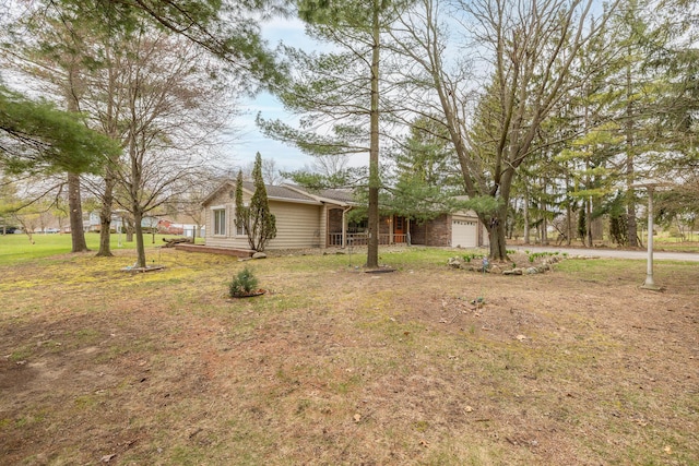 exterior space with an attached garage, a shingled roof, and a front lawn