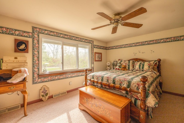 carpeted bedroom featuring baseboards, a ceiling fan, and visible vents