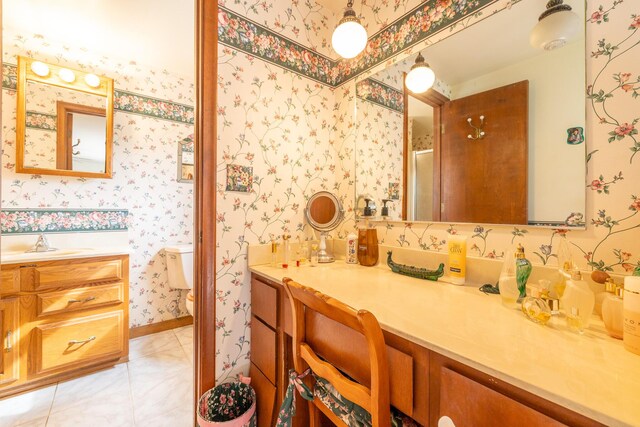 bathroom with toilet, an enclosed shower, wallpapered walls, tile patterned flooring, and vanity