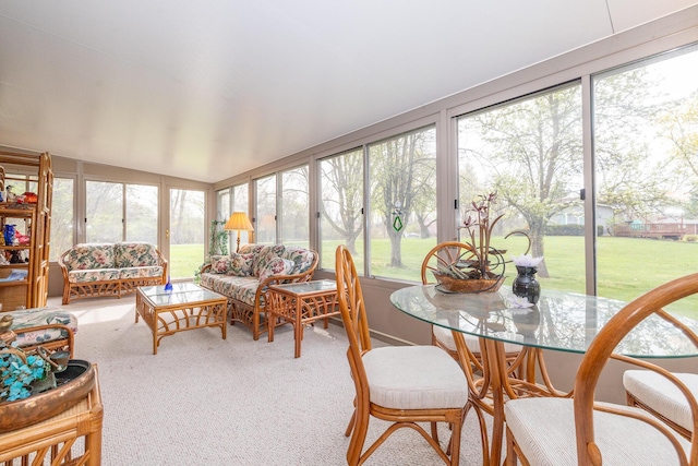 sunroom with lofted ceiling and carpet