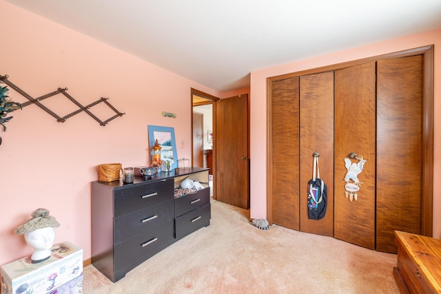 bedroom featuring light carpet and a closet