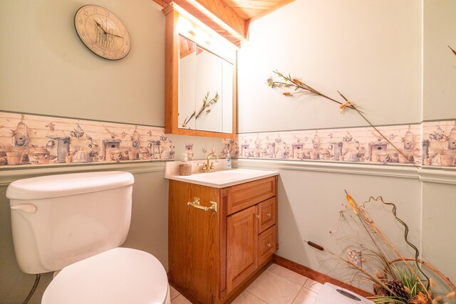 half bathroom featuring vanity, toilet, and a wainscoted wall