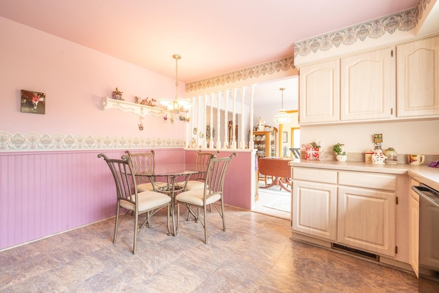 dining room with an inviting chandelier, a wainscoted wall, and visible vents