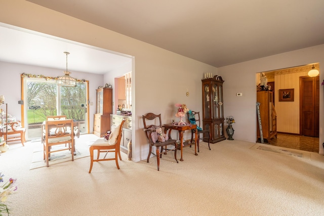 carpeted dining space with an inviting chandelier