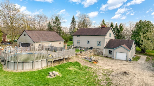 8825 Mills Rd, Manitou Beach, MI 49253 - back of house featuring a detached garage, an outdoor structure, and a chimney