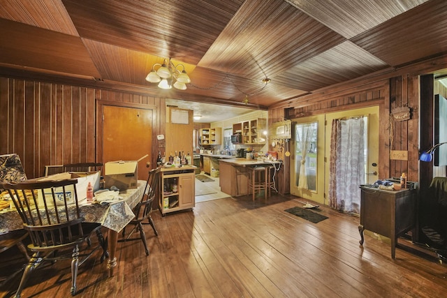 8825 Mills Rd, Manitou Beach, MI 49253 - dining area featuring wooden walls, a chandelier, wood ceiling, and hardwood / wood-style flooring