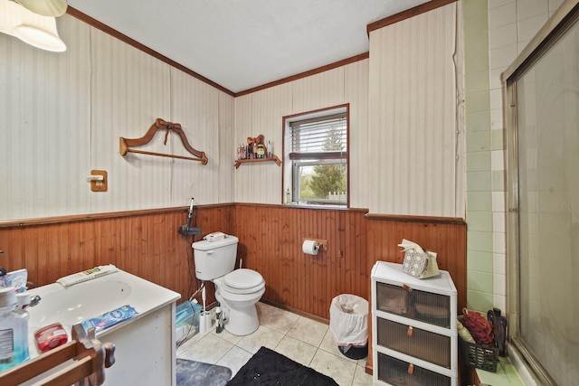 8825 Mills Rd, Manitou Beach, MI 49253 - bathroom featuring ornamental molding, a wainscoted wall, a stall shower, toilet, and tile patterned flooring