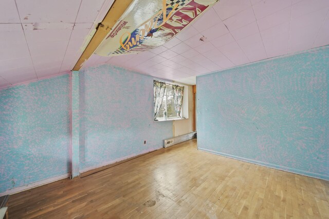 8825 Mills Rd, Manitou Beach, MI 49253 - additional living space with hardwood / wood-style floors, baseboards, and lofted ceiling