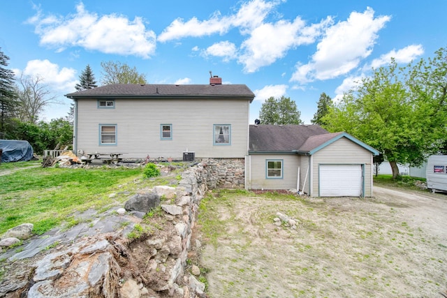 8825 Mills Rd, Manitou Beach, MI 49253 - back of house featuring a chimney, a garage, driveway, a lawn, and central AC unit