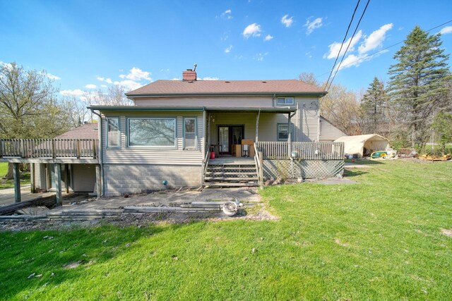8825 Mills Rd, Manitou Beach, MI 49253 - rear view of property featuring a chimney, a lawn, and a deck