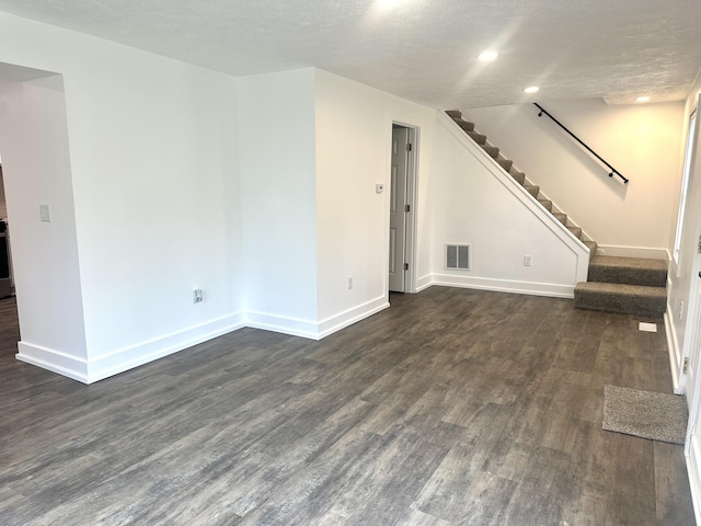 unfurnished living room with dark wood finished floors, visible vents, and baseboards
