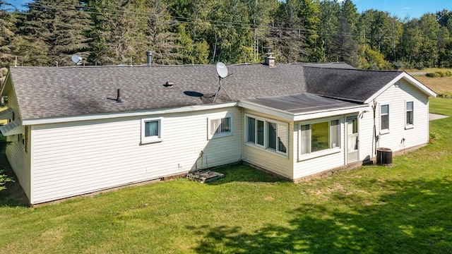 4345 W Mcnally Rd, Coleman, MI 48618 - rear view of house featuring a lawn, a shingled roof, and central AC unit