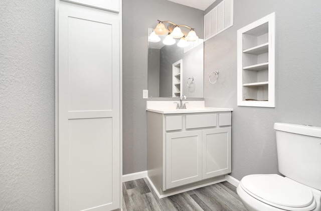 4345 W Mcnally Rd, Coleman, MI 48618 - bathroom with wood finished floors, toilet, vanity, and a textured wall