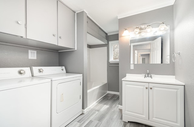 4345 W Mcnally Rd, Coleman, MI 48618 - laundry room featuring light wood-style flooring, a sink, washing machine and dryer, baseboards, and ornamental molding