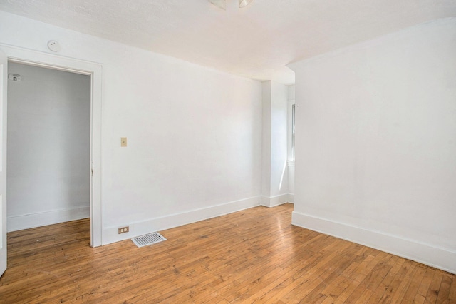 unfurnished room with baseboards, visible vents, and light wood-style floors