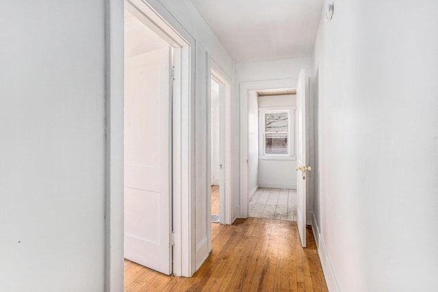hallway with baseboards and light wood finished floors