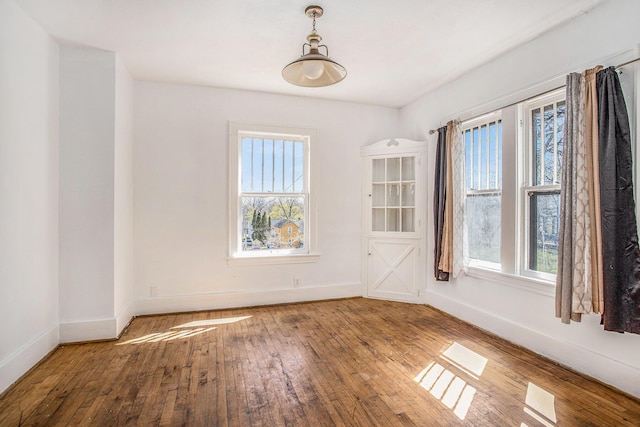 empty room featuring baseboards and hardwood / wood-style floors