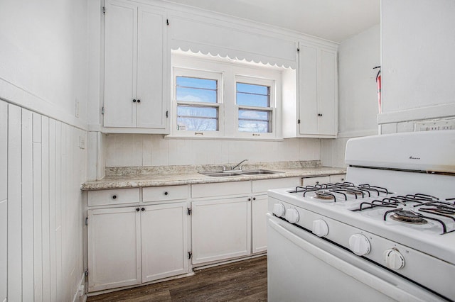 kitchen with white cabinetry, a sink, white gas range oven, and light countertops