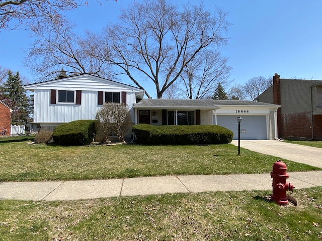 view of front of house with a front lawn, driveway, a garage, brick siding, and board and batten siding