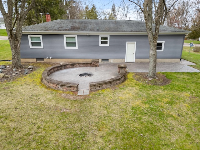 back of house featuring a lawn, roof with shingles, and a patio