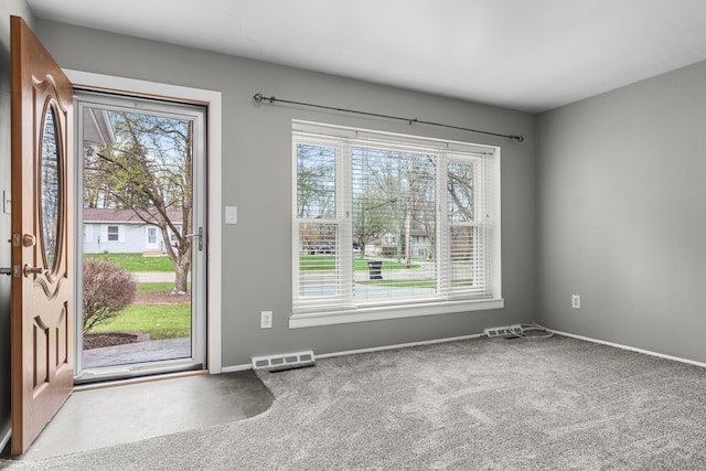 doorway to outside with baseboards, visible vents, and carpet
