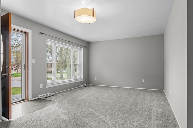 carpeted empty room with visible vents and baseboards