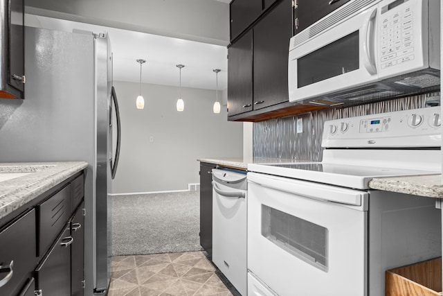 kitchen featuring dark cabinets, light carpet, white appliances, and pendant lighting
