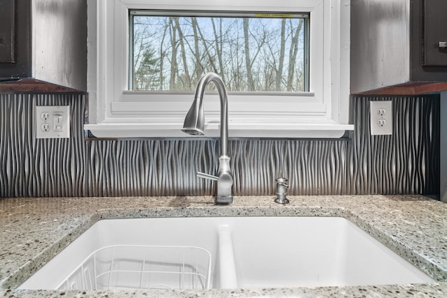 details featuring light stone countertops and a sink