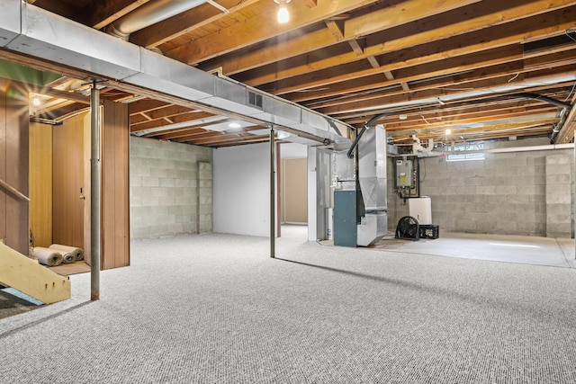 basement featuring heating unit and carpet