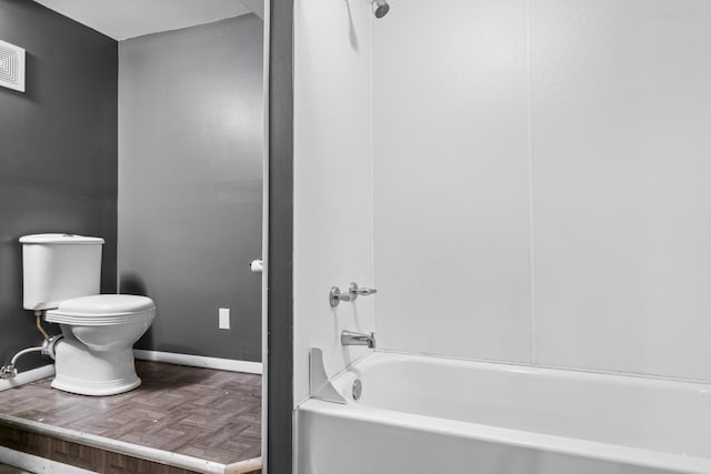 full bathroom featuring baseboards, washtub / shower combination, and toilet