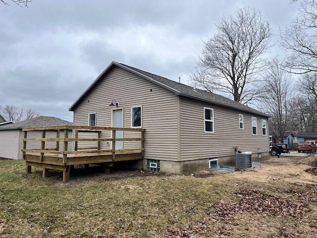rear view of house with central air condition unit and a deck