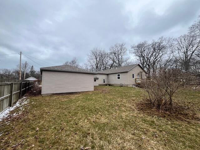 rear view of house with a lawn and fence