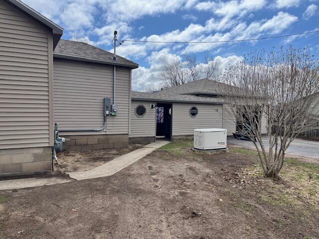 view of property exterior with roof with shingles