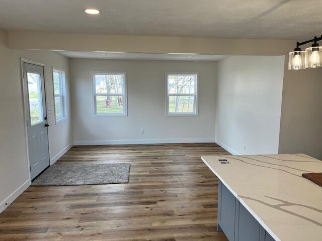 unfurnished dining area featuring wood finished floors, baseboards, and recessed lighting