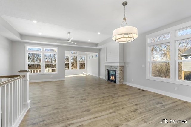 7571 Brook Villa Ct, Allendale, MI 49401 - unfurnished living room with light wood-style flooring, a stone fireplace, baseboards, recessed lighting, and a ceiling fan