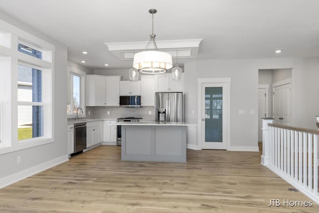 7571 Brook Villa Ct, Allendale, MI 49401 - kitchen with appliances with stainless steel finishes, a kitchen island, backsplash, white cabinetry, and light countertops