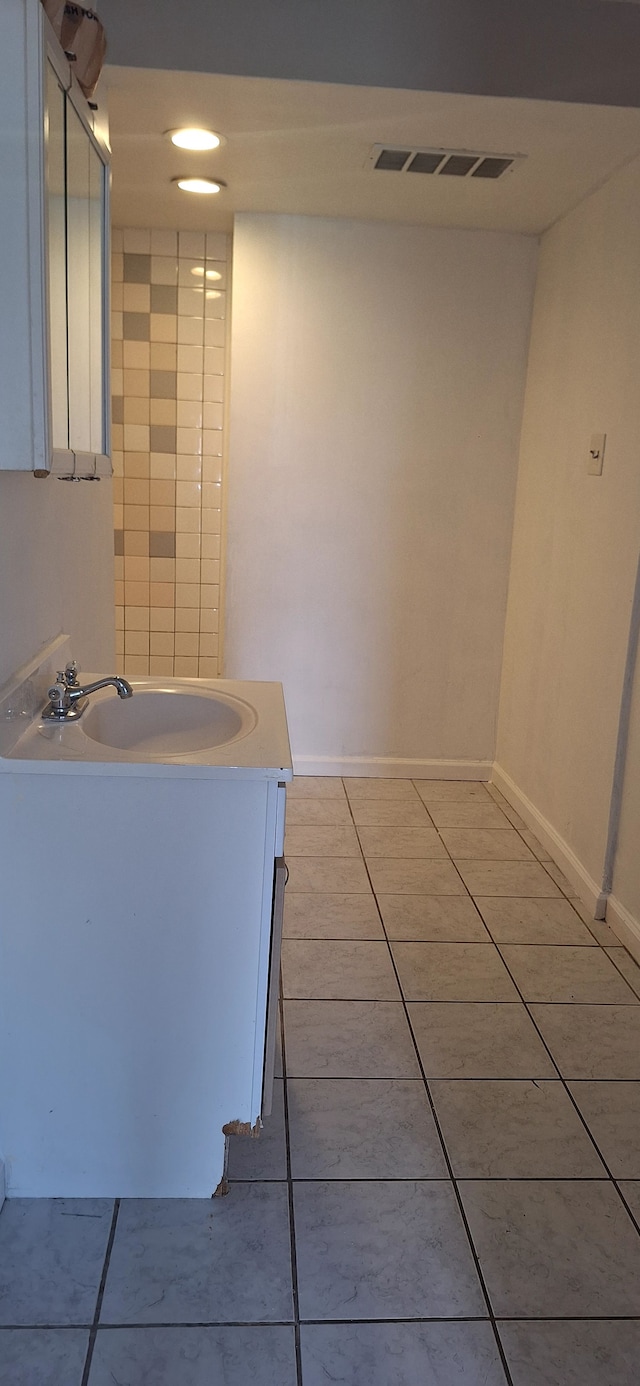 bathroom featuring visible vents, tile patterned floors, baseboards, and vanity