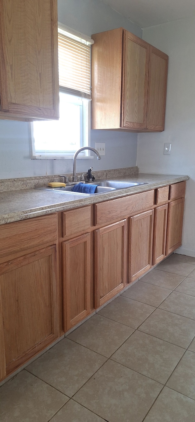 kitchen featuring light countertops, a sink, and light tile patterned floors