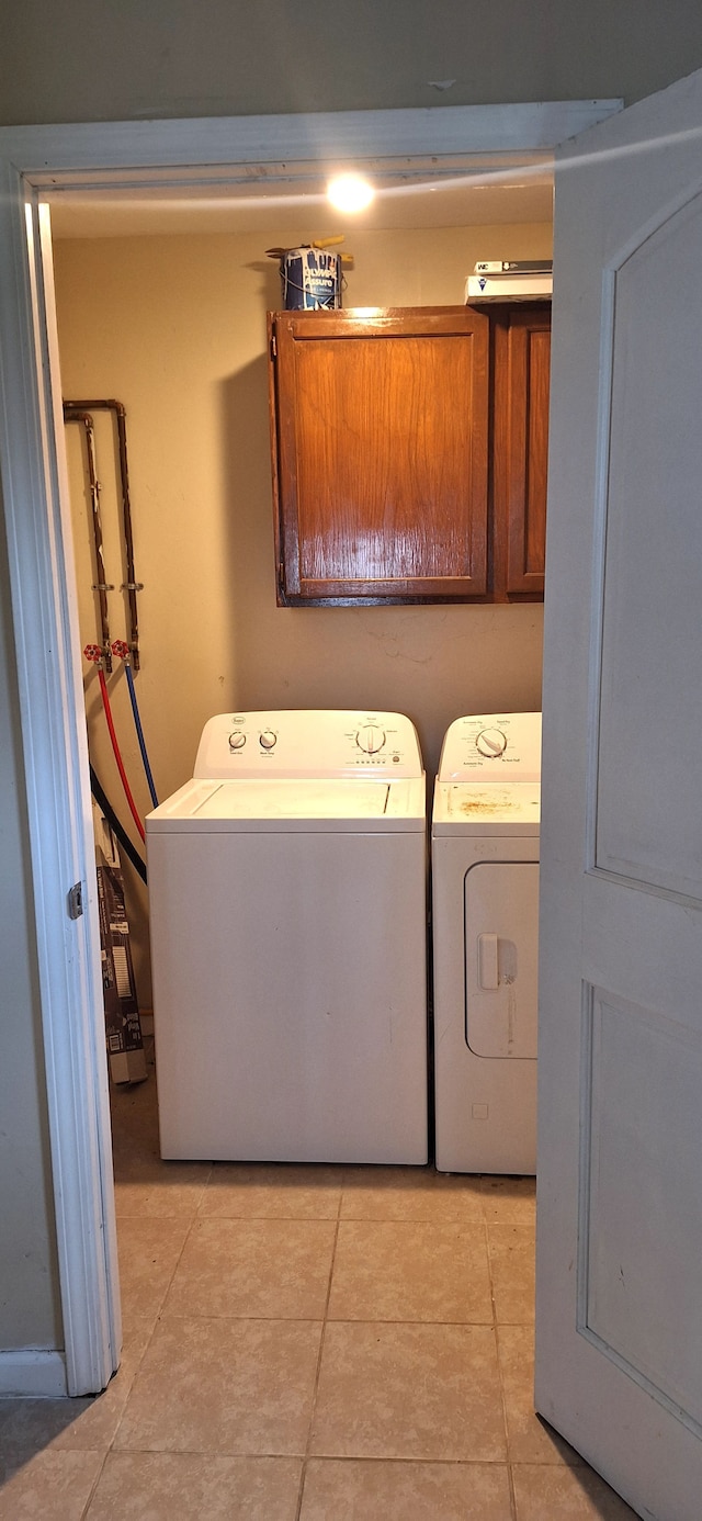 clothes washing area featuring independent washer and dryer and light tile patterned floors