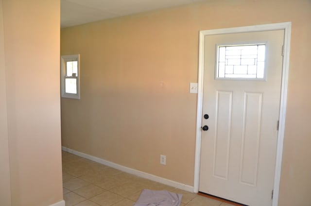 foyer featuring baseboards and light tile patterned flooring