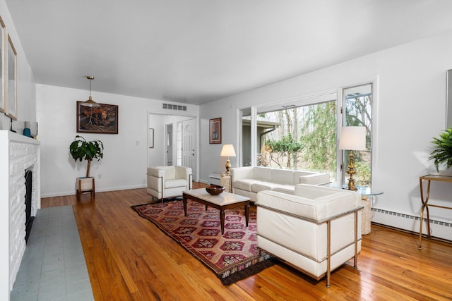 1657 Glenwood Rd, Ann Arbor, MI 48104 - living area featuring light wood-type flooring, a fireplace, a baseboard heating unit, and baseboards