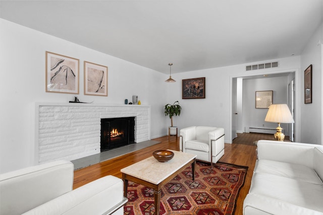 1657 Glenwood Rd, Ann Arbor, MI 48104 - living room with a brick fireplace, wood finished floors, and baseboard heating
