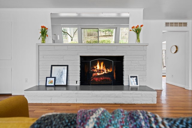 1657 Glenwood Rd, Ann Arbor, MI 48104 - living area with a warm lit fireplace, wood finished floors, and baseboards