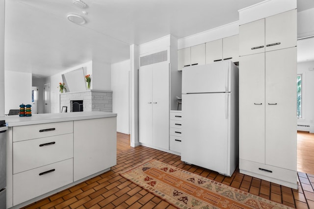 1657 Glenwood Rd, Ann Arbor, MI 48104 - kitchen with freestanding refrigerator, brick patterned flooring, white cabinetry, and light countertops
