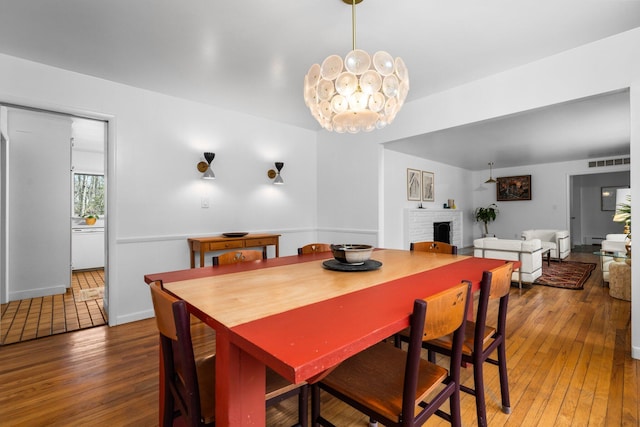1657 Glenwood Rd, Ann Arbor, MI 48104 - dining space with a brick fireplace, hardwood / wood-style floors, and a baseboard heating unit