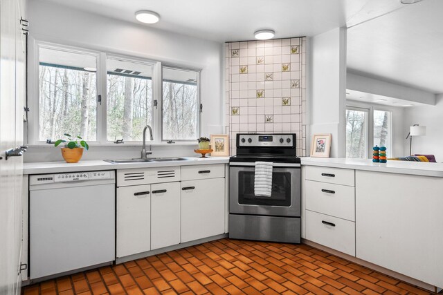 1657 Glenwood Rd, Ann Arbor, MI 48104 - kitchen featuring dishwasher, electric range, a sink, light countertops, and white cabinetry