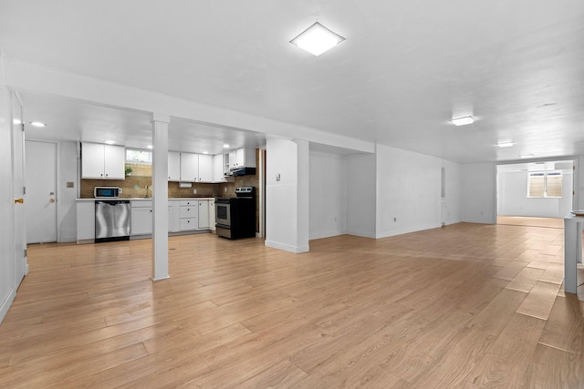 1657 Glenwood Rd, Ann Arbor, MI 48104 - unfurnished living room featuring plenty of natural light, baseboards, and light wood finished floors
