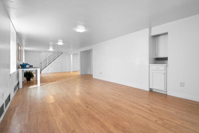 1657 Glenwood Rd, Ann Arbor, MI 48104 - unfurnished living room with stairway, light wood-style flooring, and baseboards