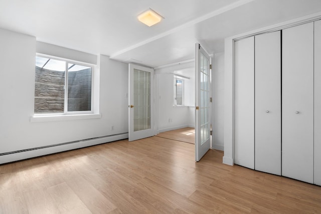 1657 Glenwood Rd, Ann Arbor, MI 48104 - unfurnished bedroom with a baseboard radiator, light wood-style flooring, and baseboards