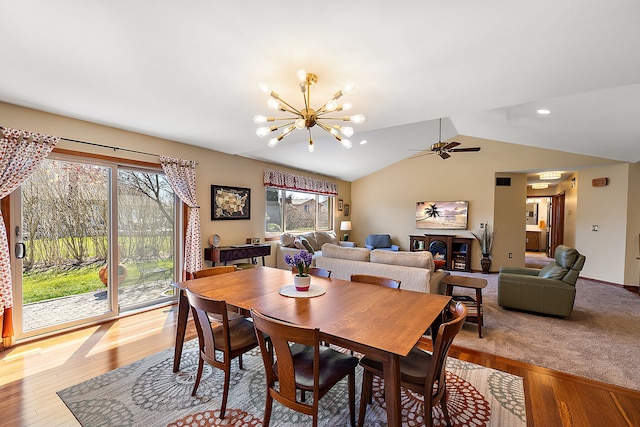 dining room with ceiling fan with notable chandelier, vaulted ceiling, recessed lighting, and light wood-style flooring